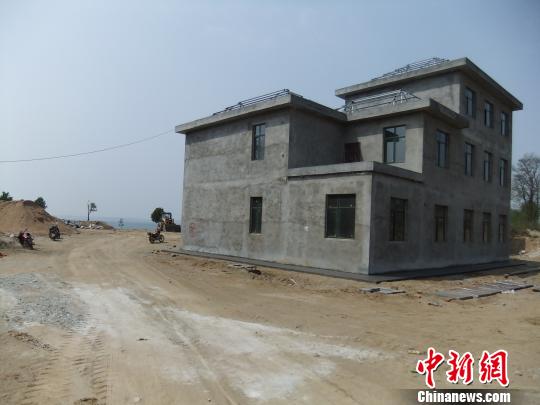鴨河水庫(kù)庫(kù)區(qū)邊的新建別墅，一面墻上寫著“拆”，另一邊在加緊施工。吳揚(yáng)　攝