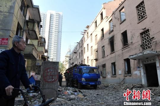 一位花甲老人站在即將拆除的樓房旁，默默地與“蘇聯(lián)樓”告別。　翟羽佳　攝